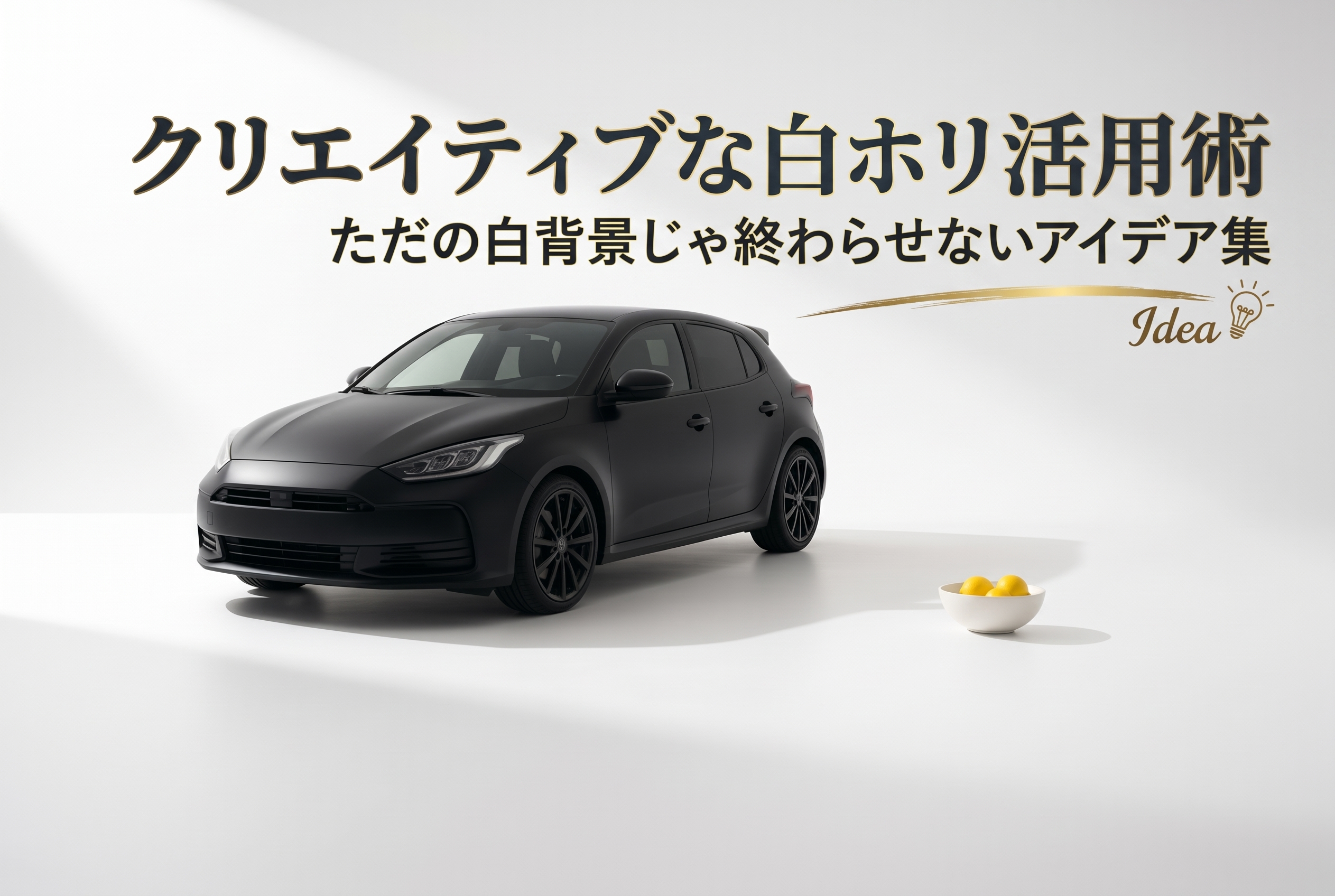 白ホリのアールが画面右奥へ大きくカーブし、手前の広い白い床にマットブラックのコンパクトカーが斜めに停まっている。車の横、少し離れた位置に黄色いレモンが3つ入った浅い白いボウルだけが置かれている。左上からの柔らかい光で、床に長い薄い影。